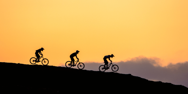 Mountainbiker fahren im Sonnenuntergang