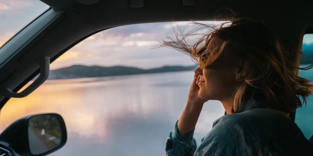 Frau mit offenem Fenster in VW California Ocean