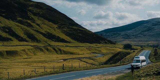 Ein Camper fährt eine schottische Landstraße entlang.