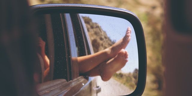 Autospiegel Foto mit Füßen die aus dem Fenster hängen