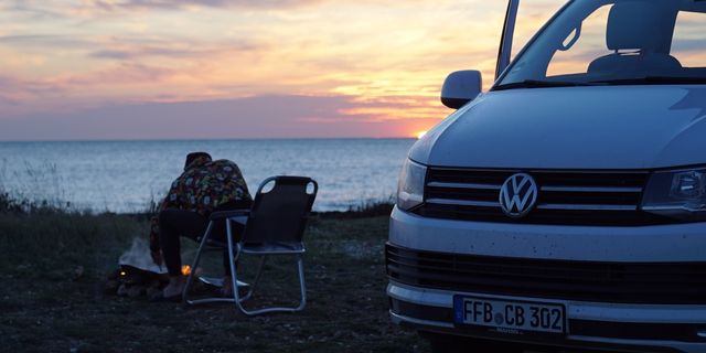 VW California T6.1 with a sunset over the sea