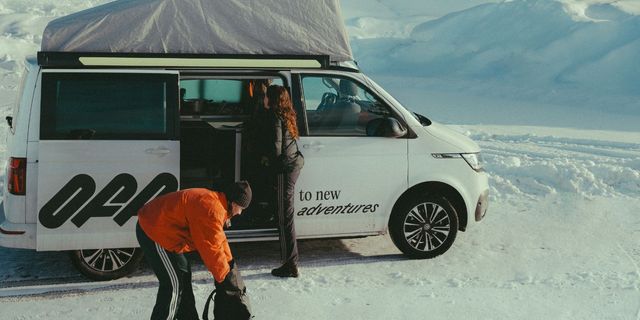 Freundinnen vor ihrem Off Camper im Schnee beim Wintercaping