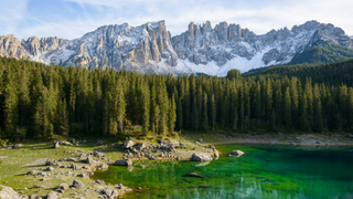 Karersee Camping: Im glasklaren Wasser des Karersees spiegeln sich Tannen und Berge