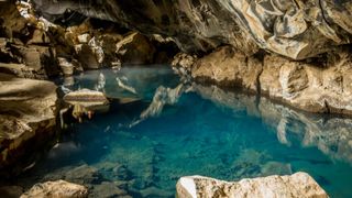 Die Höhle Grjótagjá auf Island mit klarem, türkisblauen Wasser