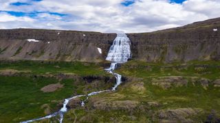 Der Dettifoss Wasserfall auf Island in grüner und steiniger Landschaft: Ein Highlight auf der Island Rundreise!