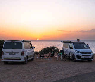 Zwei CamperBoys Camper bei Sonnenuntergang an der Küste