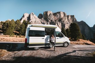 Off camper in front of a mountain massif in the Dolomites while camping in low season