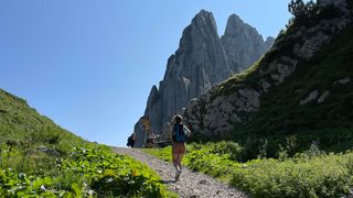 Junge Frau wandert beim Camping in der Schweiz auf Felsmassiv zu