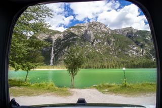 Dieser Campingplatz am Walchensee ist ein Traum: Blick aus dem hinteren Fenster eines Wohnmobils auf das Seeufer und Berge