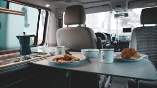 VW Beach Innenraumaufnahme mit gedecktem Frühstückstisch.