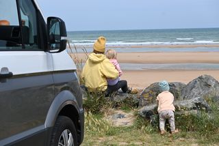 Mother with two children with camper on the beach in Holland