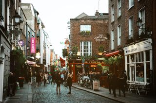 Kleine Gasse in Galway mit Cafés und Läden auf beiden Seiten des Pflasterweges.