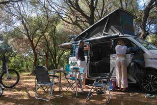 Friends at a campsite in the forest while camping in Corsica