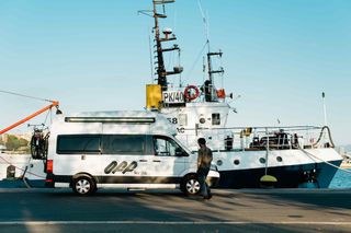 White off camper at the harbor in front of the ferry