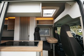 Der Eingangsbereich des Kastenwagen: Essbereich, Küchenzeile und Sitzgelegenheiten.