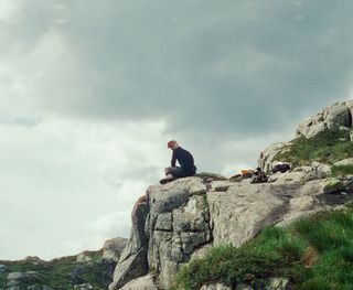 Junger Mann irgendwie im Nirgendwo auf einem Felsvorsprung in Norwegen. 