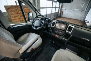 The driver's cabin of the Mooveo travel van by CamperBoys - driver and passenger seat light leather and rotatable
