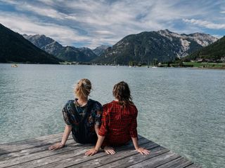 Zwei Frauen sitzen auf einem Steg am Achensee.