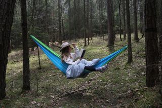 Frau liegt in einer Hängematte im Wald