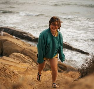 Frau an seliger Küste - Meer im Hintergrund