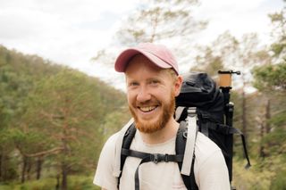 Ein Mann beim Wandern in Norwegen lacht in die Kamera.