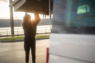 Frau macht Camper von Kofferraum zu