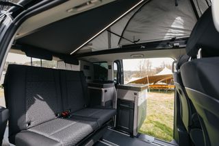 Pössl Campstar interior with open pop-up roof and outdoor kitchen