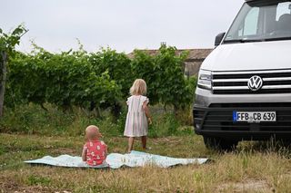 Young children playing in front of camper van