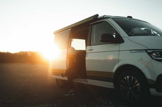 Woman tying her shoes in the camper while wintering in Portugal