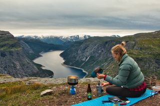 Steffi vom Off Guide sitzt hoch oben auf einem Bergplateau und macht Brotzeit.