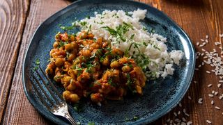 Teller gefüllt mit veganem Kichererbsen Curry und Reis.
