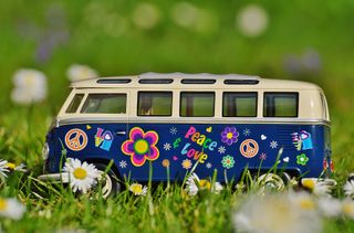 Kleines VW Bulli Spielzeug mit Hippie Blumenmuster im Gras