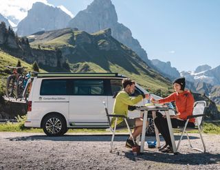 VW California Ocean couple eating in the mountains