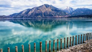 Zaun am Ufer des Walchensees vor Bergkulisse